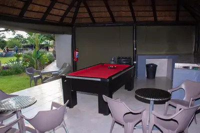 a pool table on a patio with chairs at Sasavona Game Lodge in Warmbaths