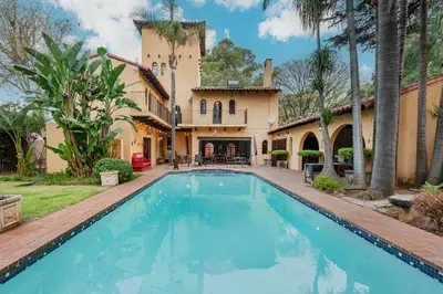 a swimming pool in front of a house at Airport Tower Lodge in Kempton Park