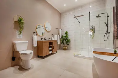 a bathroom with a toilet and a tub and a sink at Airport Tower Lodge in Kempton Park