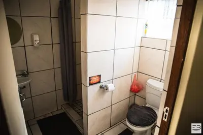 a small bathroom with a shower and a toilet at Geluksfontein Private Game Farm in Cullinan