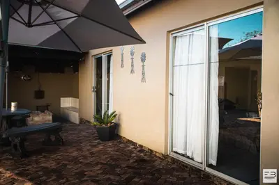 a patio with an umbrella next to a building at Geluksfontein Private Game Farm in Cullinan