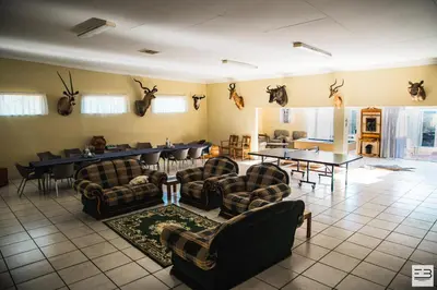 a living room with chairs and tables and antlers on the wall at Geluksfontein Private Game Farm in Cullinan