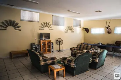 a living room with couches and a table in a room at Geluksfontein Private Game Farm in Cullinan