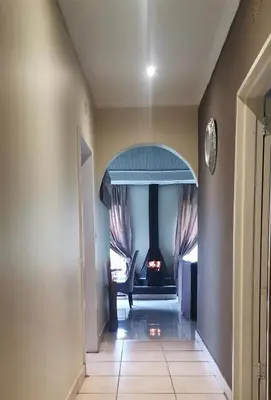 a hallway with a room with a chair and a fireplace at Angelmalatji guesthouse in Graskop