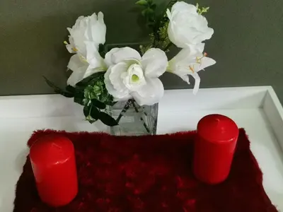a vase with white flowers and two red candles at Angelmalatji guesthouse in Graskop
