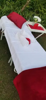 two beds with red and white pillows on the grass at Angelmalatji guesthouse in Graskop