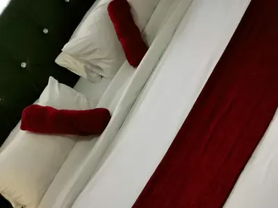 two beds with red and white pillows on them at Angelmalatji guesthouse in Graskop