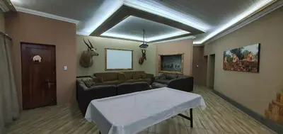 a living room with a couch and a table at Tranquillity Holiday Home in Marloth Park