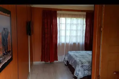 a bedroom with a bed and a window at Tranquillity Holiday Home in Marloth Park