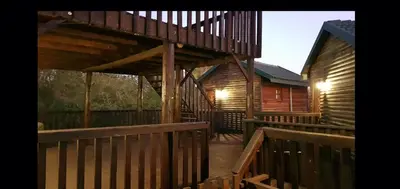 a large wooden deck with stairs to a cabin at Tranquillity Holiday Home in Marloth Park