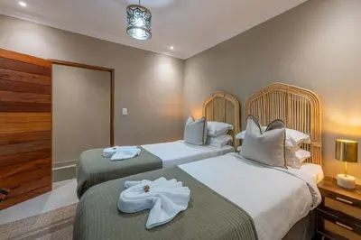 two beds in a hotel room with towels on them at Bushbaby Valley Lodge in Hazyview