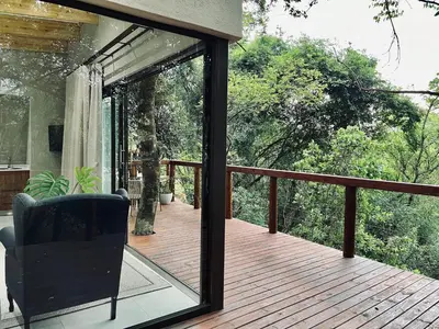 a screened in porch with a chair on a deck at Bushbaby Valley Lodge in Hazyview