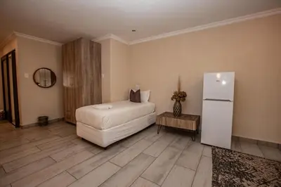 a room with a refrigerator and a white couch at Bushbaby Valley Lodge in Hazyview