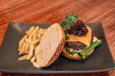 a hamburger and french fries on a plate at Bushbaby Valley Lodge in Hazyview
