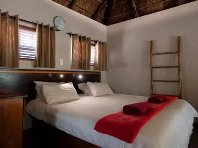 a bedroom with a large white bed with a red blanket at Mabalingwe Elephant Lodge 267-7 & 267-8 in Mabula