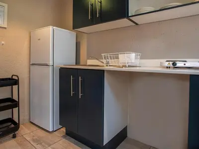 a kitchen with a white refrigerator and black cabinets at Mabalingwe Elephant Lodge 267-7 & 267-8 in Mabula