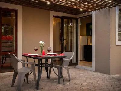 a table with chairs and wine glasses on a patio at Mabalingwe Elephant Lodge 267-7 & 267-8 in Mabula