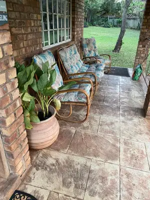 two chairs and a plant on a patio at Die Kothuis in Malelane