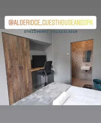 a room with a bed and a desk and a door at Arghasbnb in Burgersfort