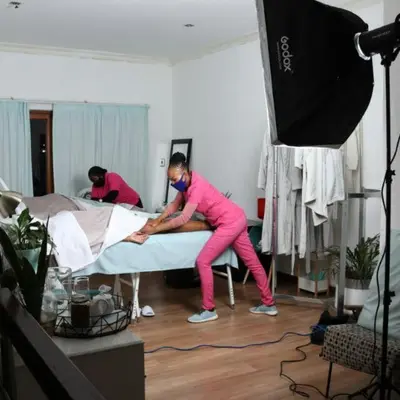 two people are making a bed in a room at Arghasbnb in Burgersfort