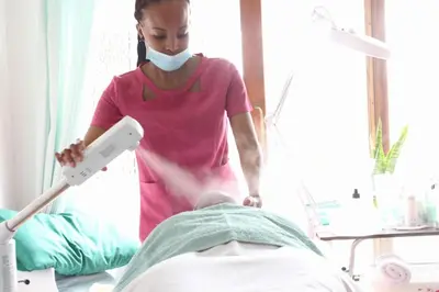 a woman in a hospital room with a wii remote at Arghasbnb in Burgersfort