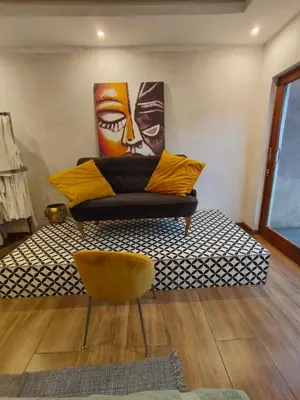 a couch in a room with a painting on the wall at Arghasbnb in Burgersfort