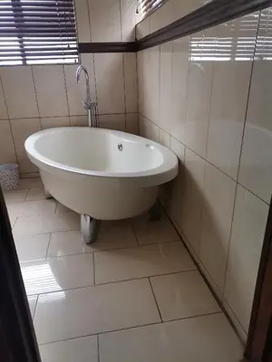 a bath tub in a bathroom with white tiles at Arghasbnb in Burgersfort