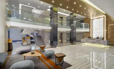 a large lobby with chairs and tables in a building at Menlyn apartment with ensuit Regency Hotel in Pretoria