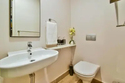 a bathroom with a white sink and a toilet at Menlyn apartment with ensuit Regency Hotel in Pretoria