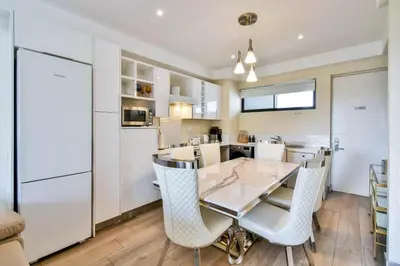 a kitchen and dining room with a table and chairs at Menlyn apartment with ensuit Regency Hotel in Pretoria