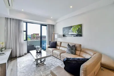 a living room with a couch and a table at Menlyn apartment with ensuit Regency Hotel in Pretoria