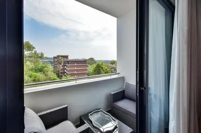 a room with a window with a view of a city at Menlyn apartment with ensuit Regency Hotel in Pretoria