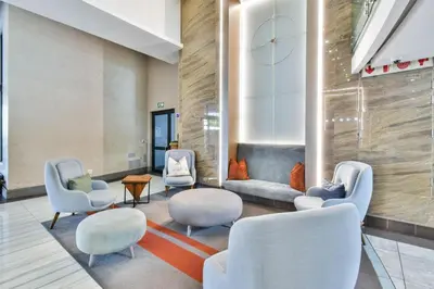 a waiting room with white chairs and tables at Menlyn apartment with ensuit Regency Hotel in Pretoria
