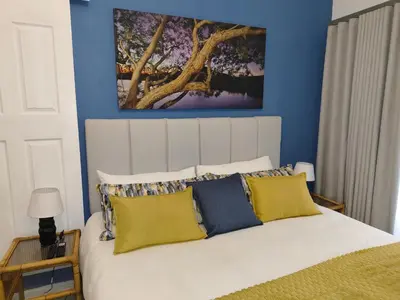 a bedroom with a large white bed with blue walls at The Garden Inn Guesthouse in Modimolle