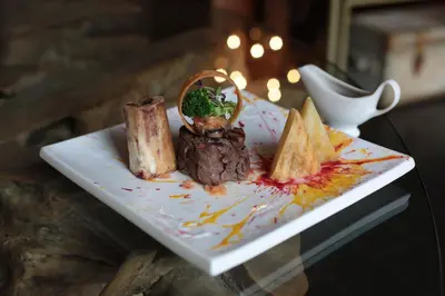 a plate of food with meat and chips on a table at Palala Boutique Game Lodge and Spa in Tom Burke