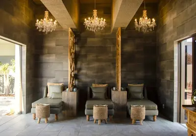 a lobby with two chairs and chandeliers at Palala Boutique Game Lodge and Spa in Tom Burke