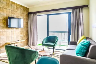 a living room with a couch and chairs and a television at Insaka 3 The Blyde Lagoon Experience in Pretoria