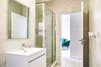a bathroom with a sink and a shower with a mirror at Insaka 3 The Blyde Lagoon Experience in Pretoria