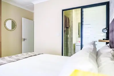 a bedroom with a bed and a glass shower at Insaka 3 The Blyde Lagoon Experience in Pretoria