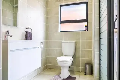 a bathroom with a toilet and a sink and a window at Insaka 3 The Blyde Lagoon Experience in Pretoria
