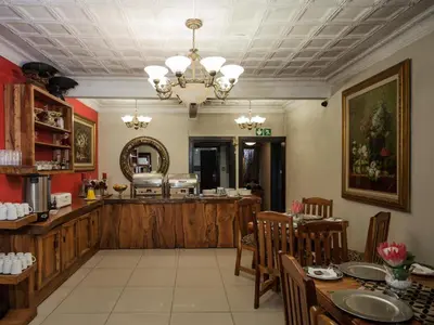 a restaurant with a dining room with a table and chairs at Dunwoodie Travel Lodge in Pretoria