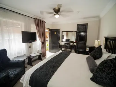 a bedroom with a large white bed and a television at Dunwoodie Travel Lodge in Pretoria