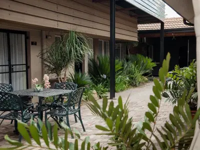 a patio with a table and chairs and plants at Dunwoodie Travel Lodge in Pretoria