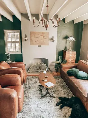 a living room with leather couches and a table at Battiss Guest House in Pretoria