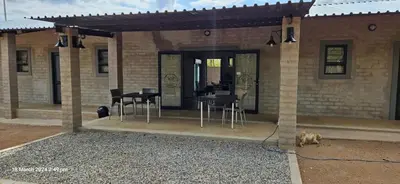 a house with a dog sitting in front of it at Kolope Lodge in Alldays