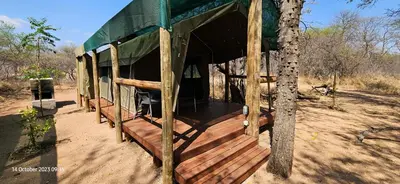a building with a wooden deck next to a tree at Kolope Lodge in Alldays