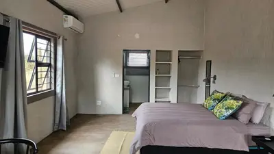 a bedroom with a bed in a room with a window at Kolope Lodge in Alldays