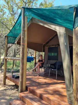 a woman sitting in a tent at Kolope Lodge in Alldays