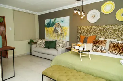 a living room with a bed and a couch at Pumbaa Wildlife Park & Accommodation in Nelspruit