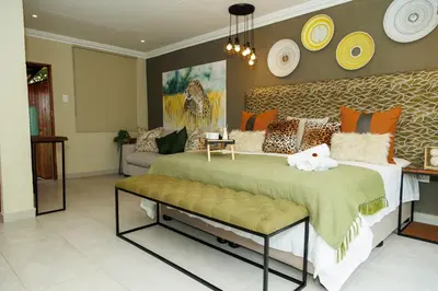 a bedroom with a large bed and a couch at Pumbaa Wildlife Park & Accommodation in Nelspruit